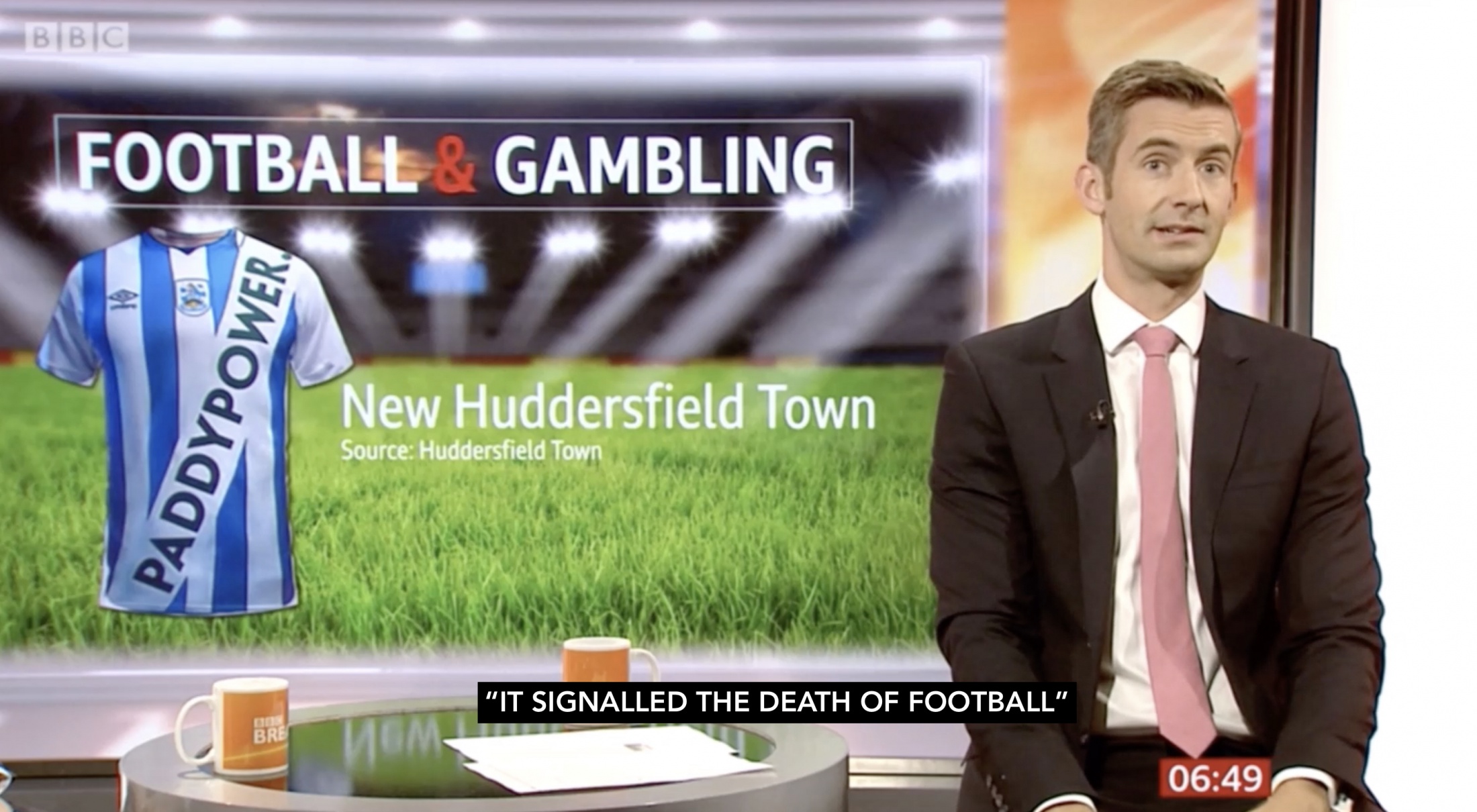 BBC Breakfast presenter discussing the Paddy Power Huddersfield shirt with the headline 'Football & Gambling' on screen and the subtitle 'It signalled the death of football'.