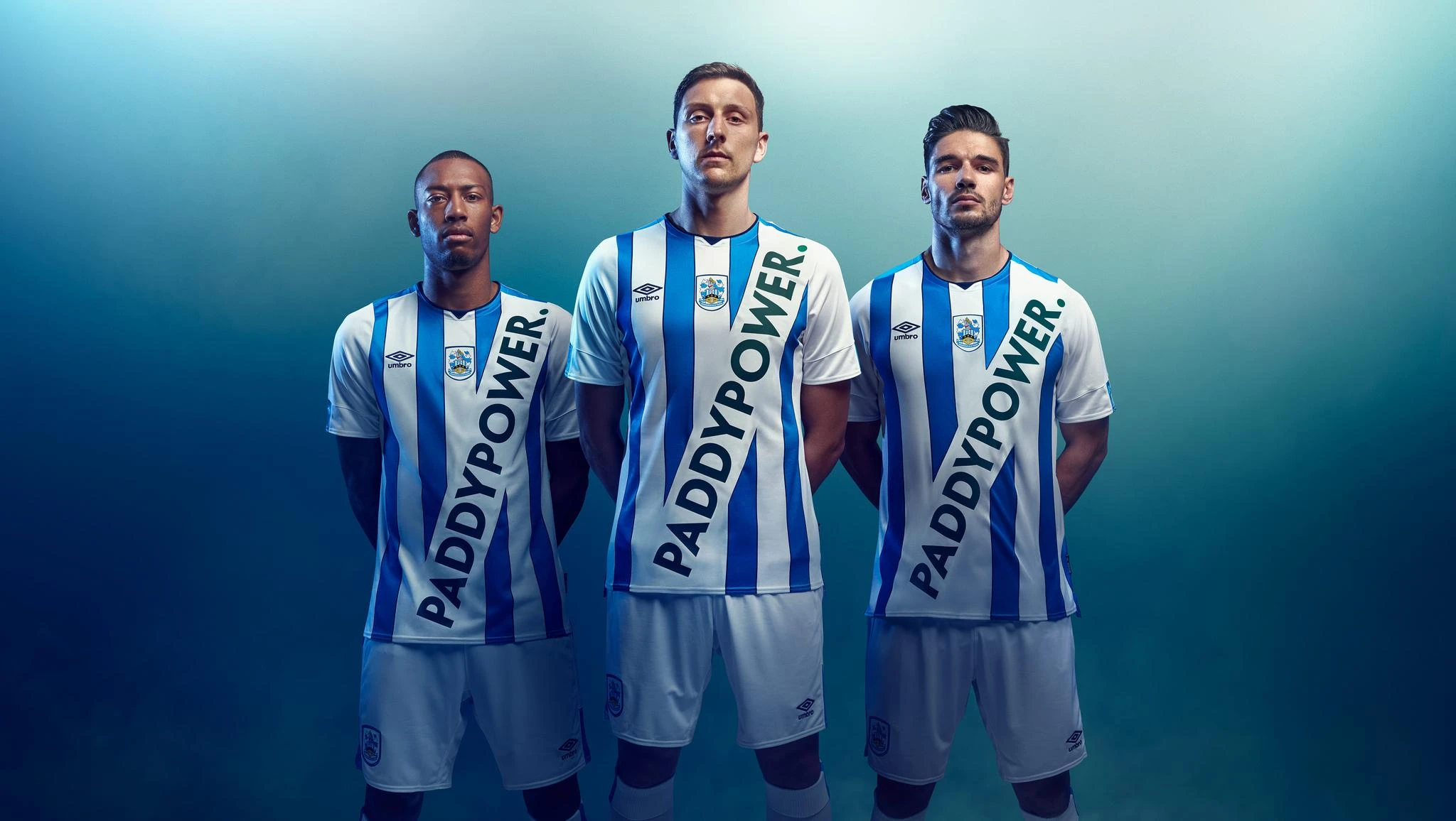 Three Huddersfield Town players in the over-branded Paddy Power kit, the diagonal sash sponsorship that briefly stopped the internet.